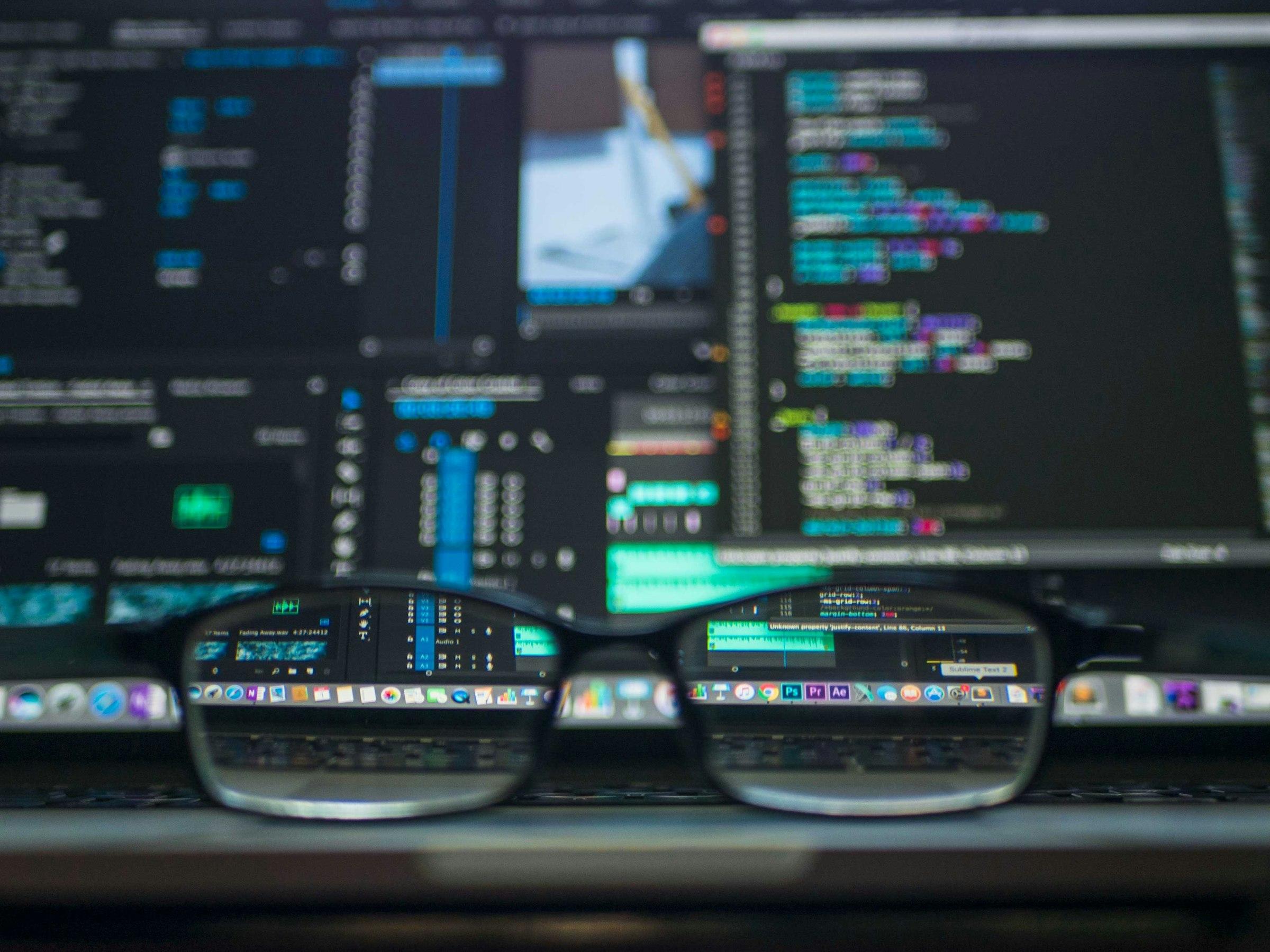Glasses focusing source code displayed on a monitor